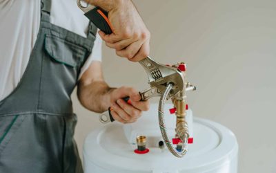 Man replacing water heater using wrench