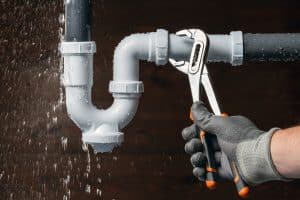 a leaky pipe being replaced by a plumber's wrench