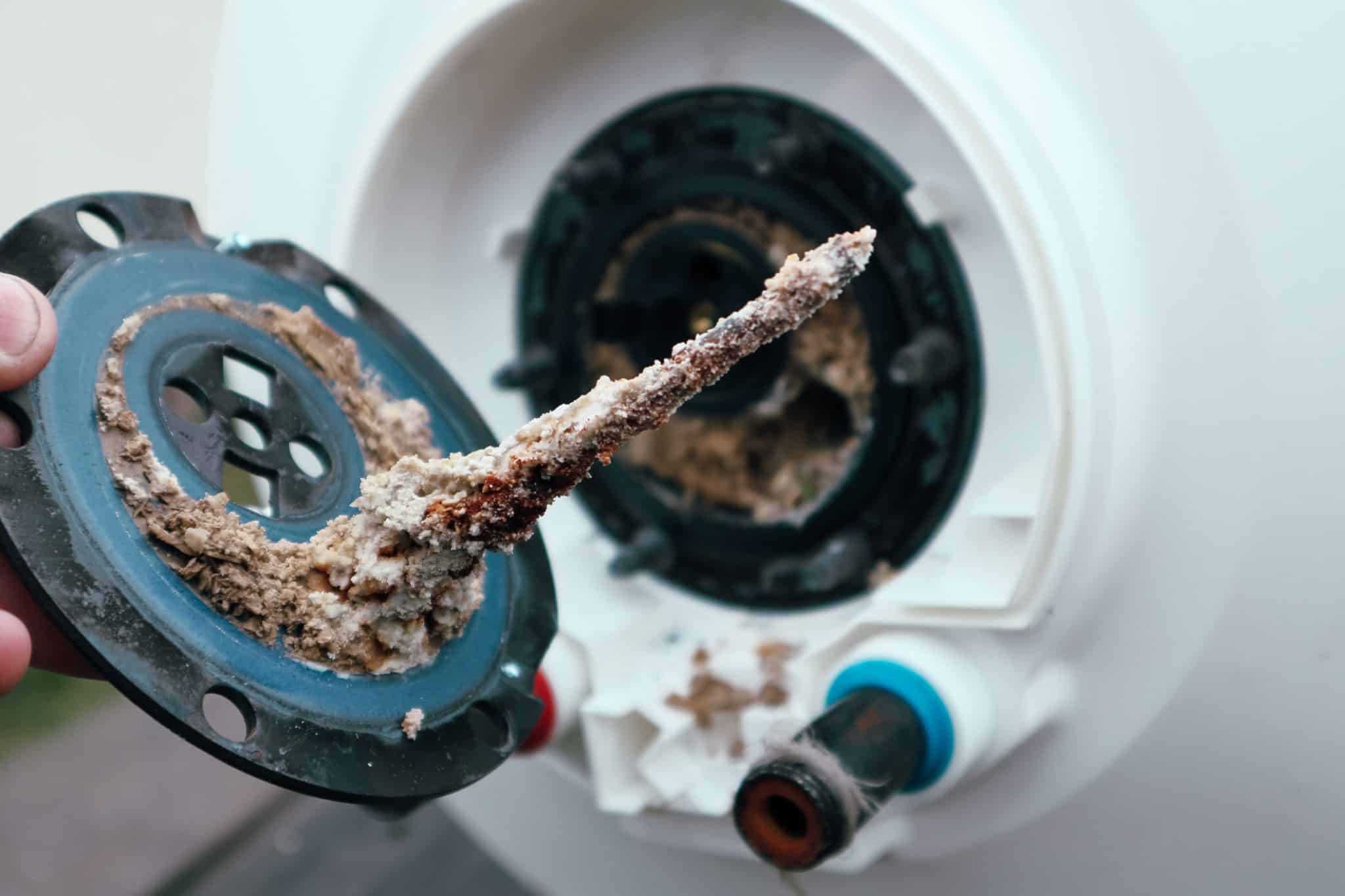 Sediment build up inside a hot water tank being repaired by our plumbers.