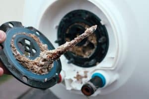 Sediment build up inside a hot water tank being repaired by our plumbers.